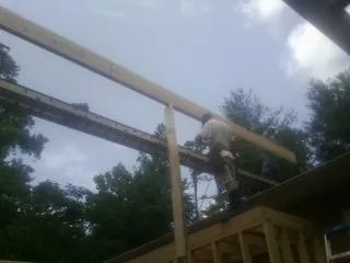 Carpenter setting a ridge beam over a new addition frame — Ice Dam Removal by Roofing Brothers in Potlatch