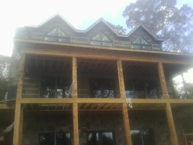 Dormers and porch framing on a large log home under construction — Roof Coating work by our crew in Potlatch