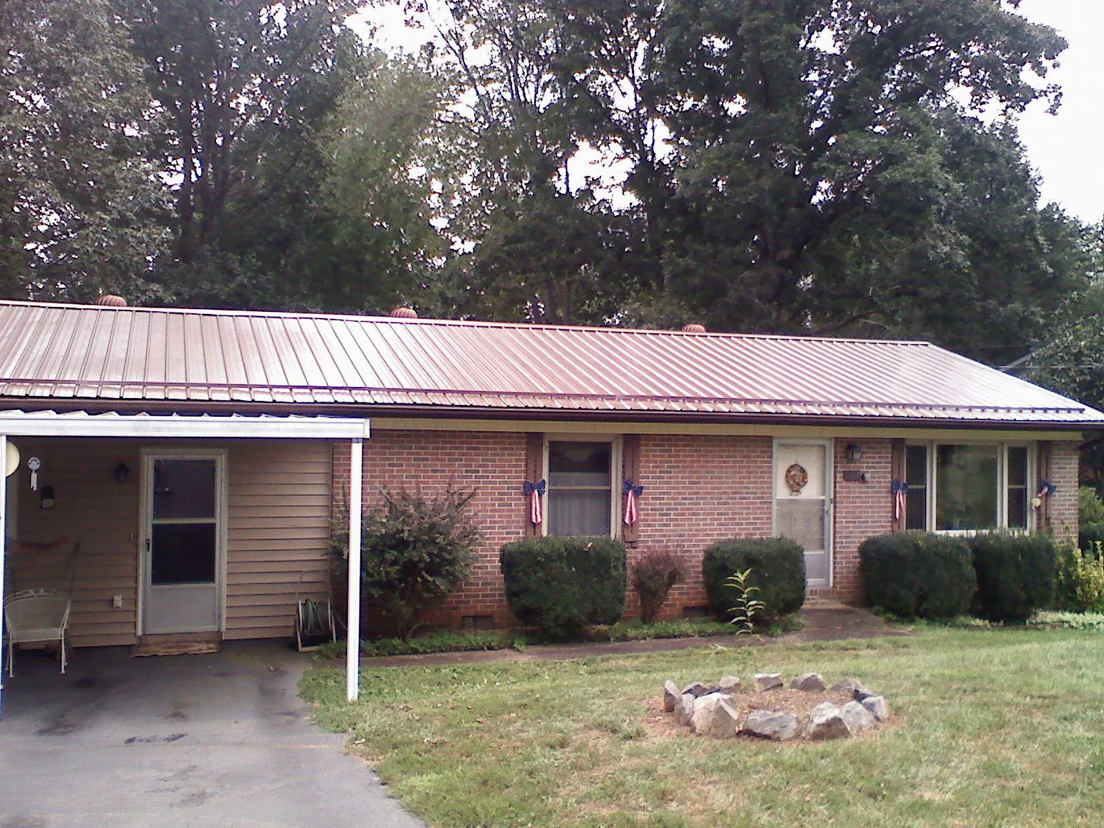 Bronze metal roof and carport on a brick ranch home — Roof Repair work by our crew in Potlatch